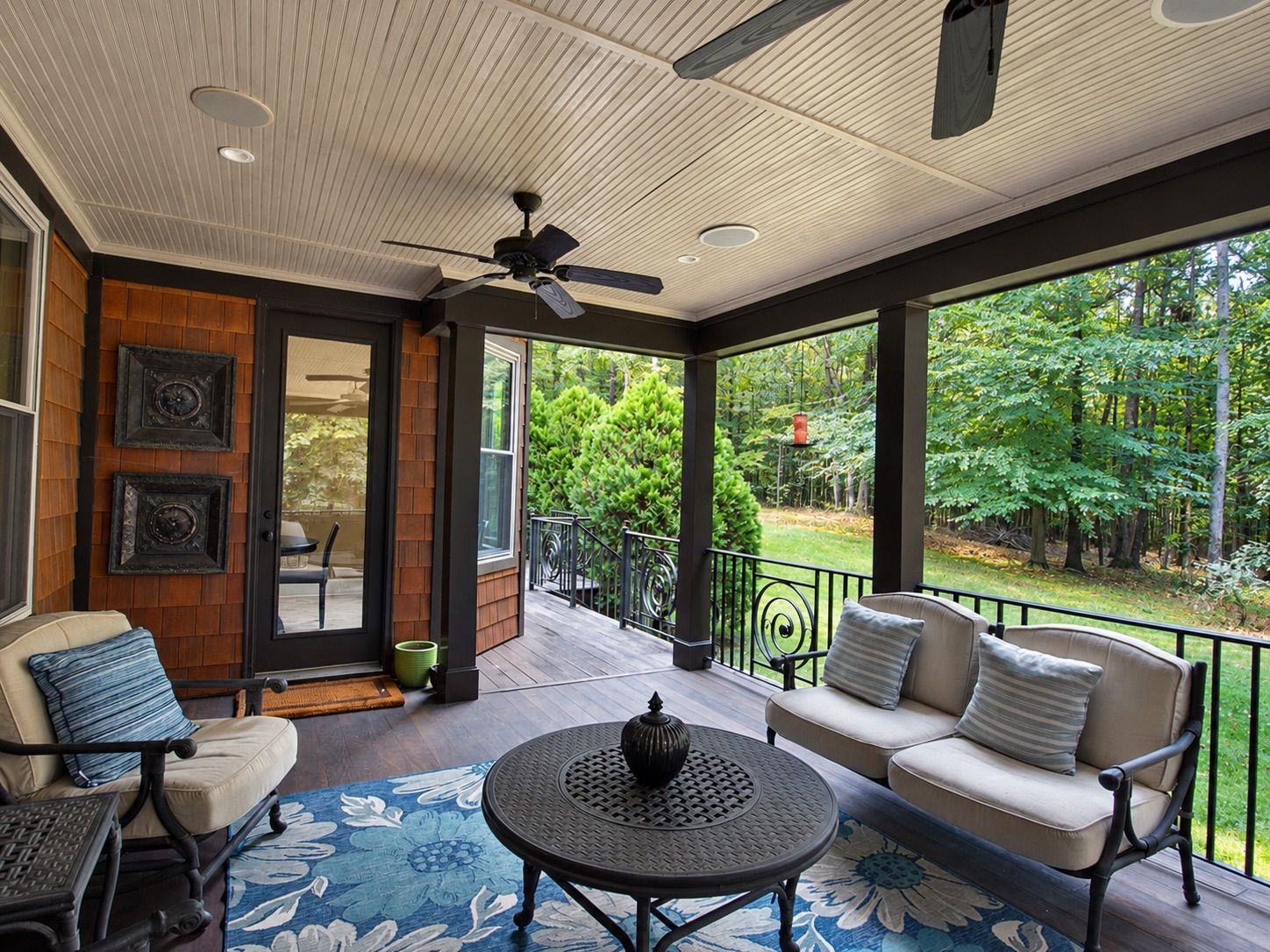 Covered porch seating area overlooking the backyard