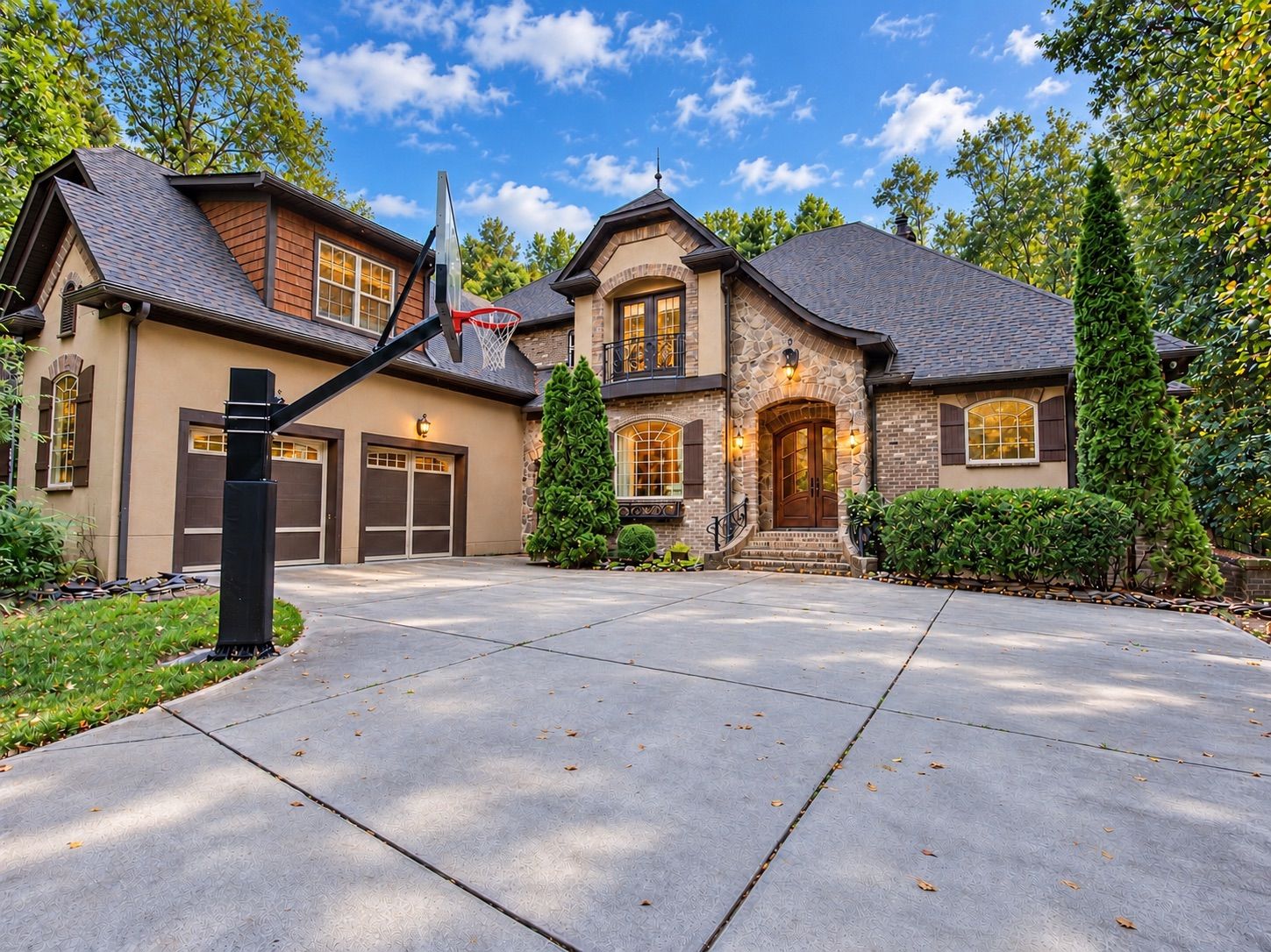 Front exterior of a stone and stucco home with three-car garage