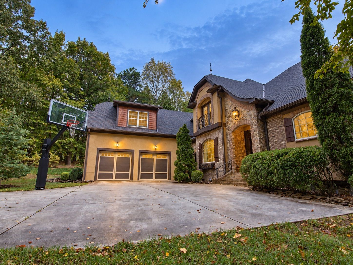 Front of the home at dusk with garage and entry lights on