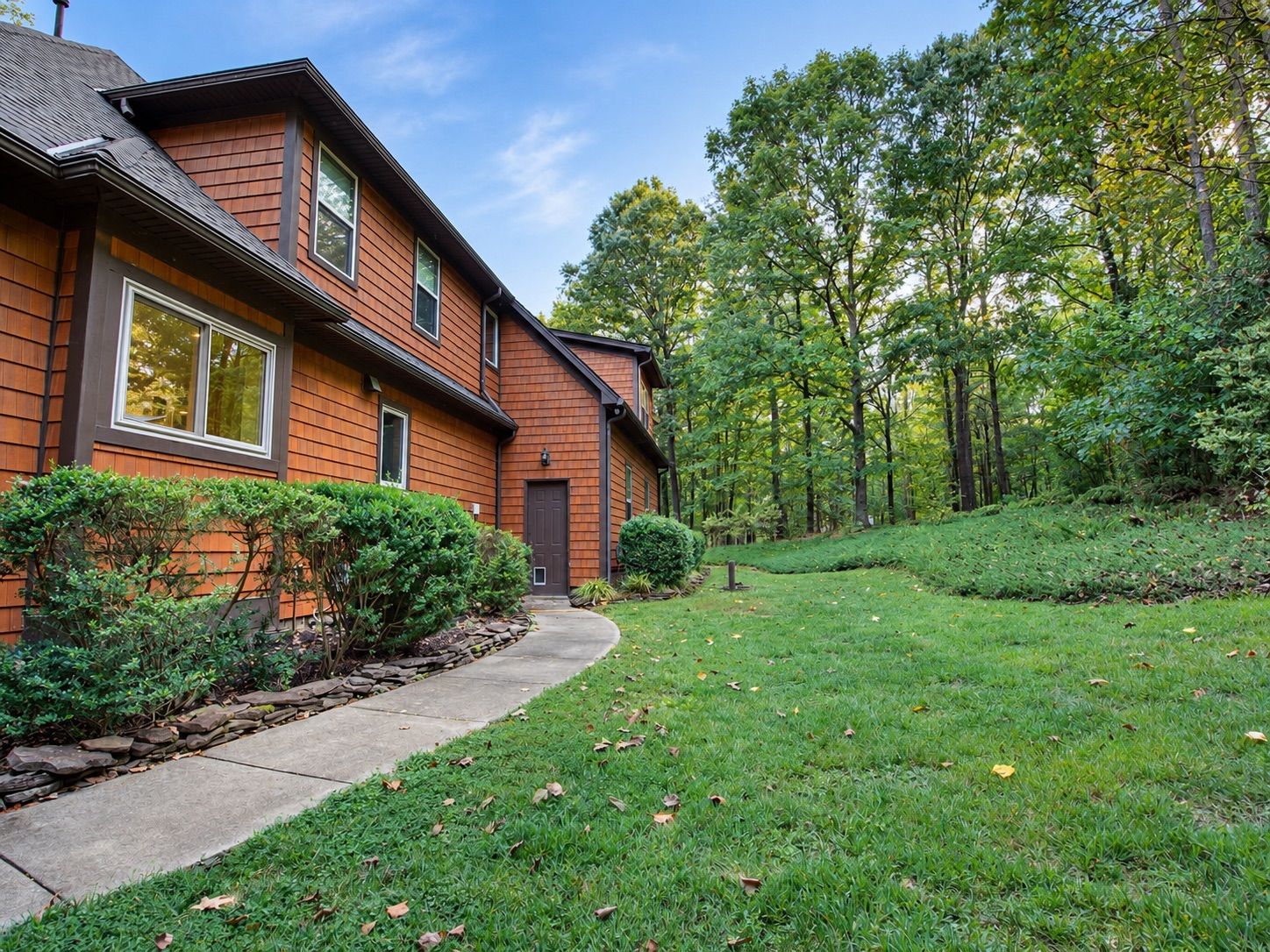Side of the home with landscaped path and mature trees