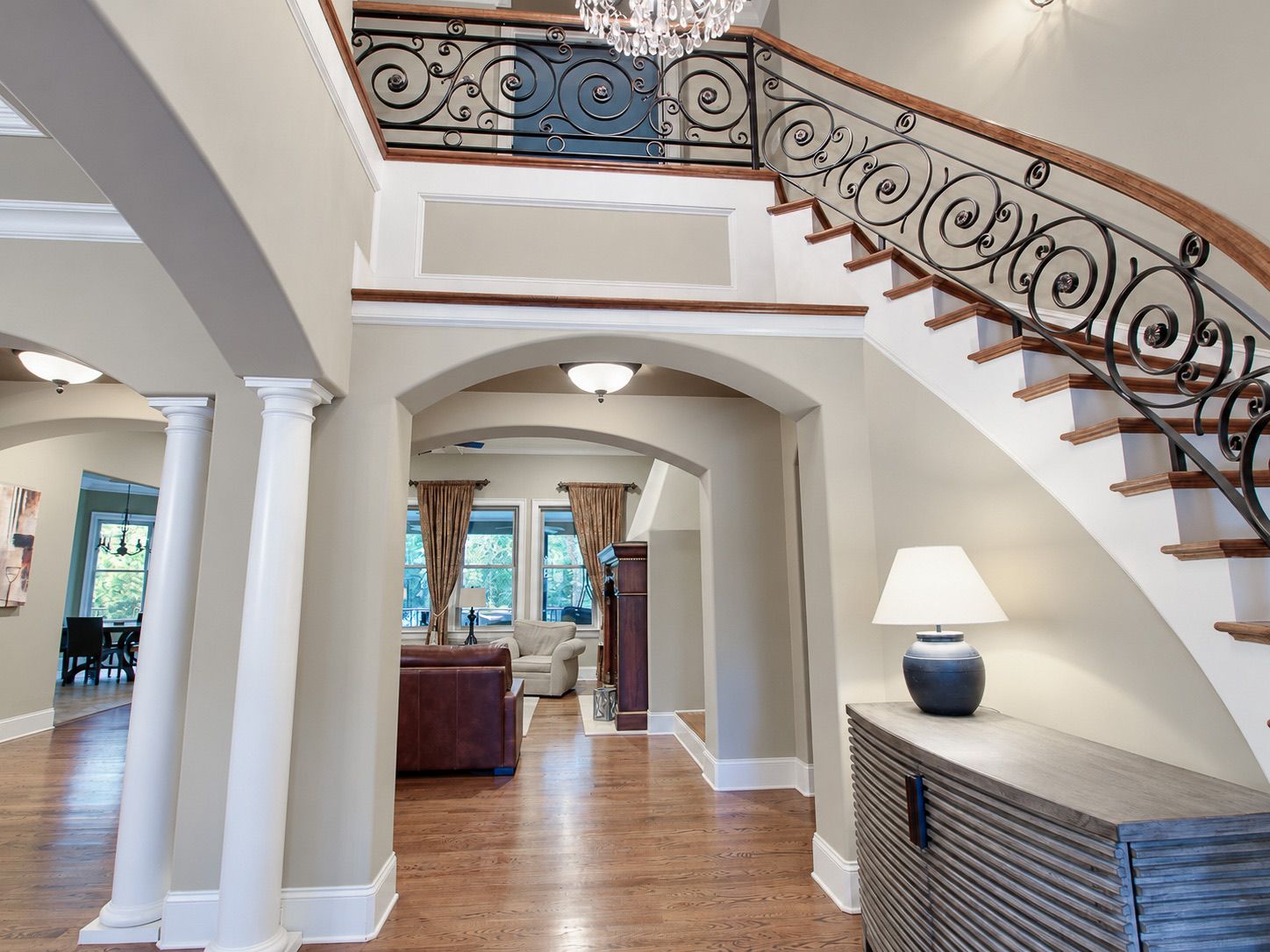 Foyer with curved staircase, iron railing and columns