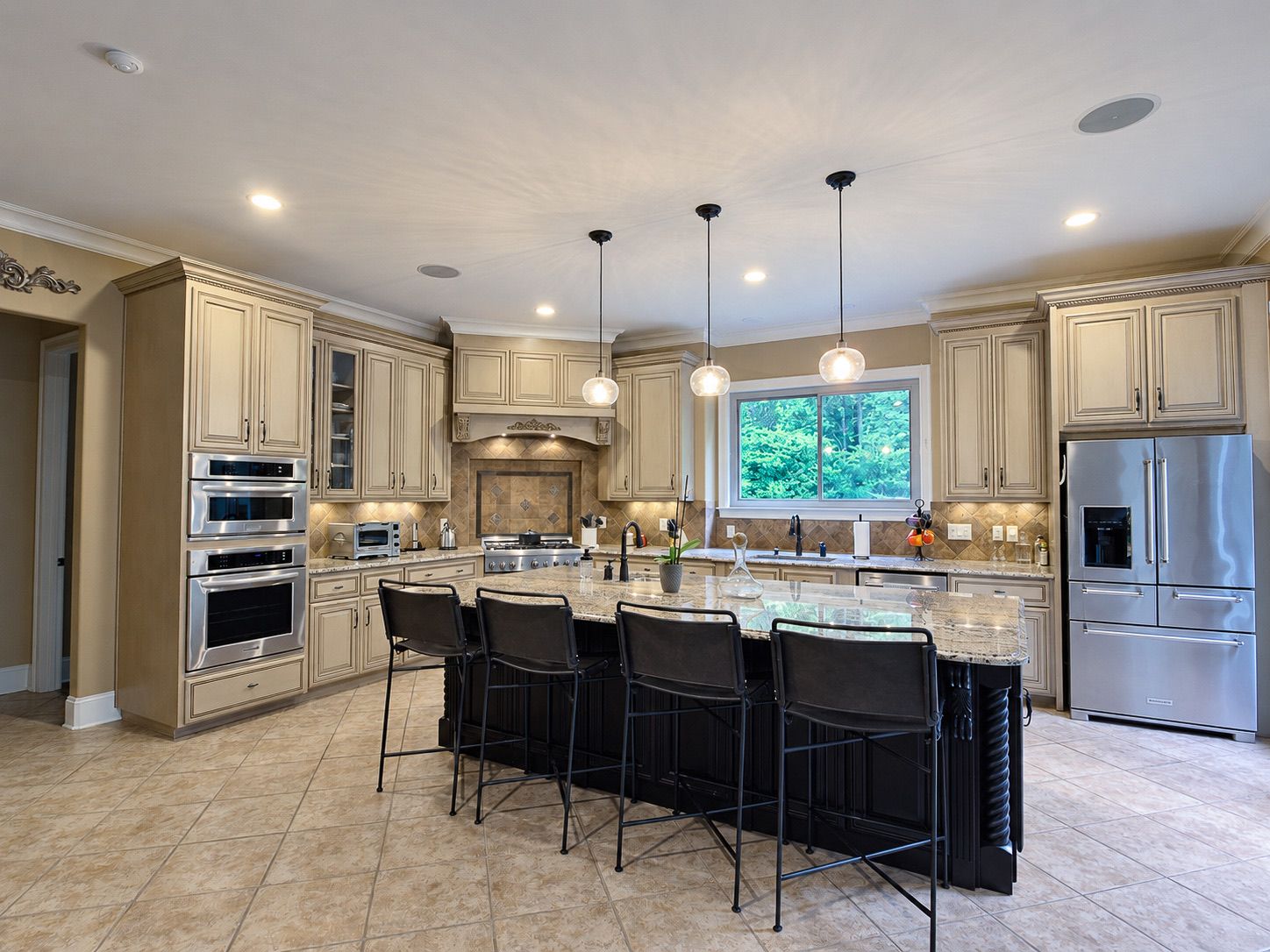 Kitchen with seating island, double ovens and stainless appliances