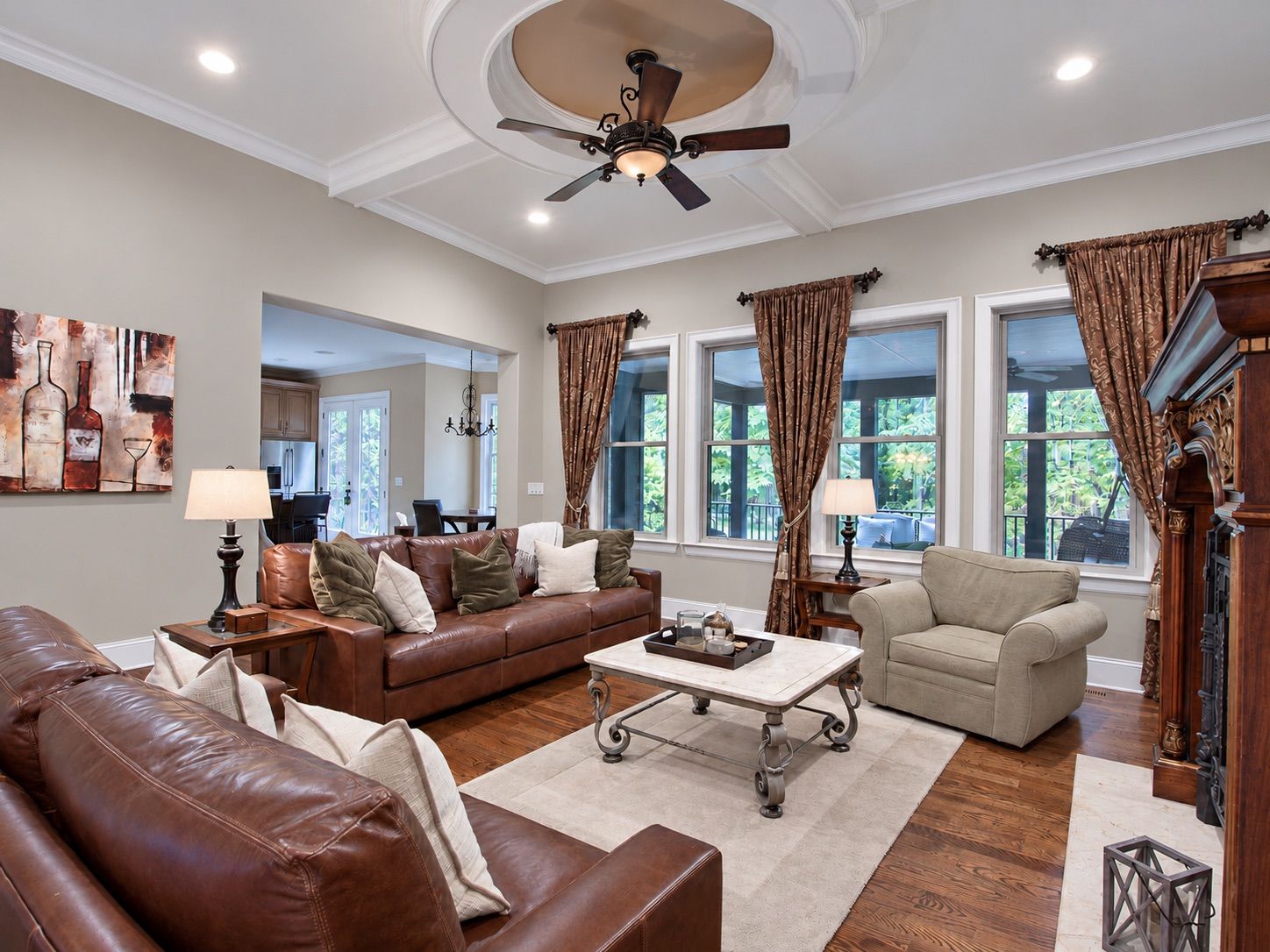 Living room with coffered ceiling, leather sofas and wall of windows