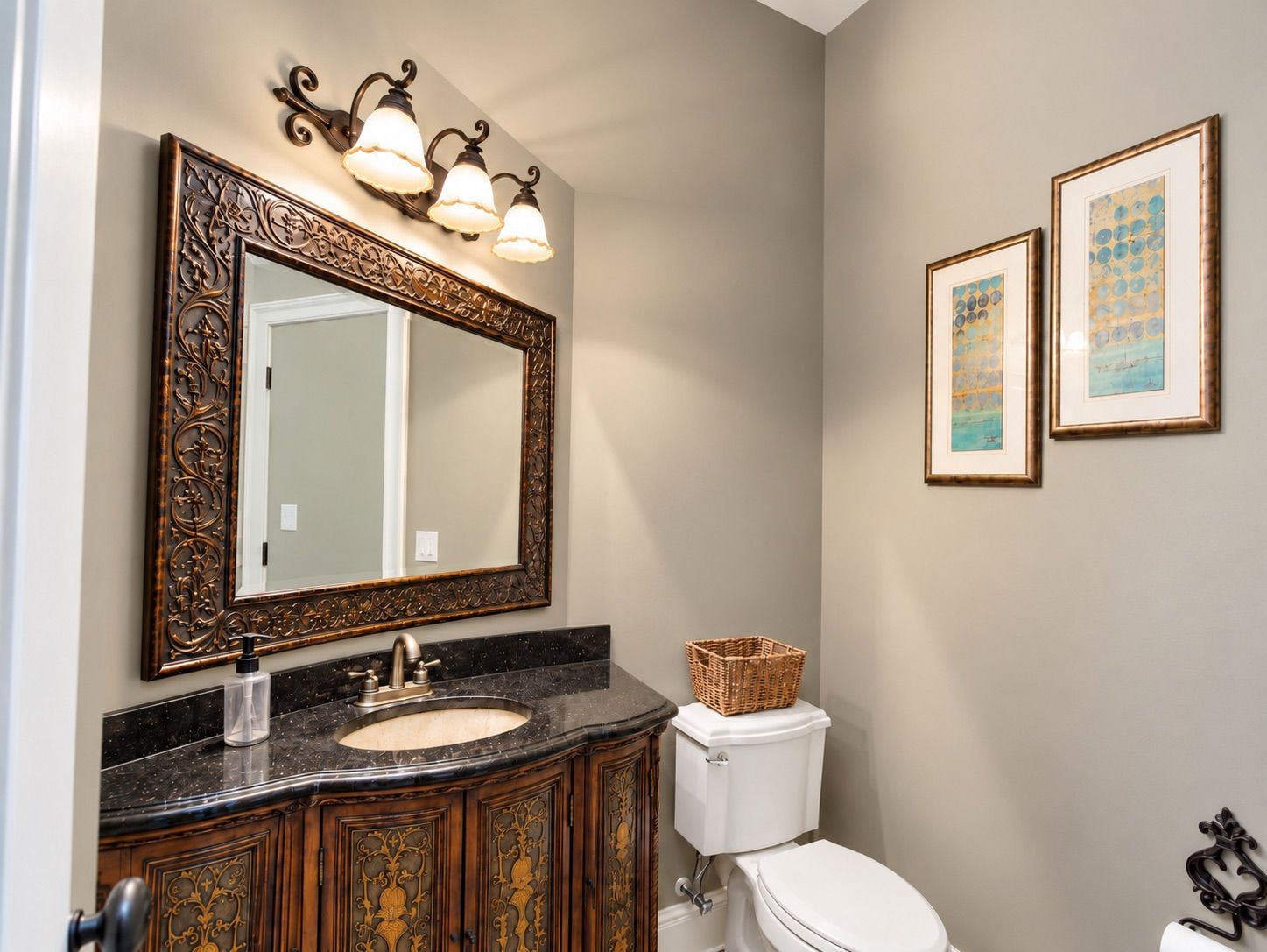 Bathroom with carved wood vanity and ornate mirror